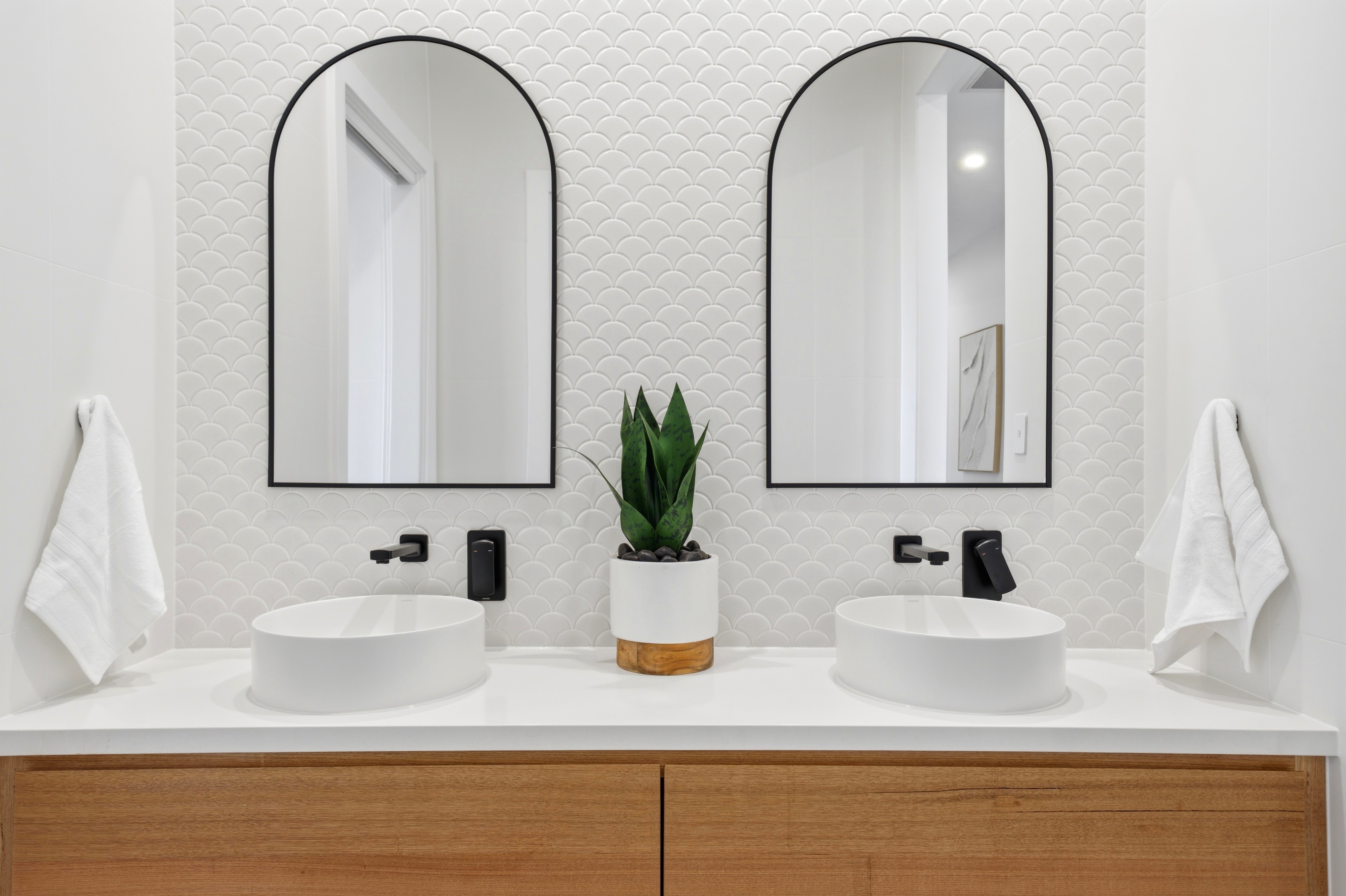 Dual vanity with arched mirrors and feature tiling