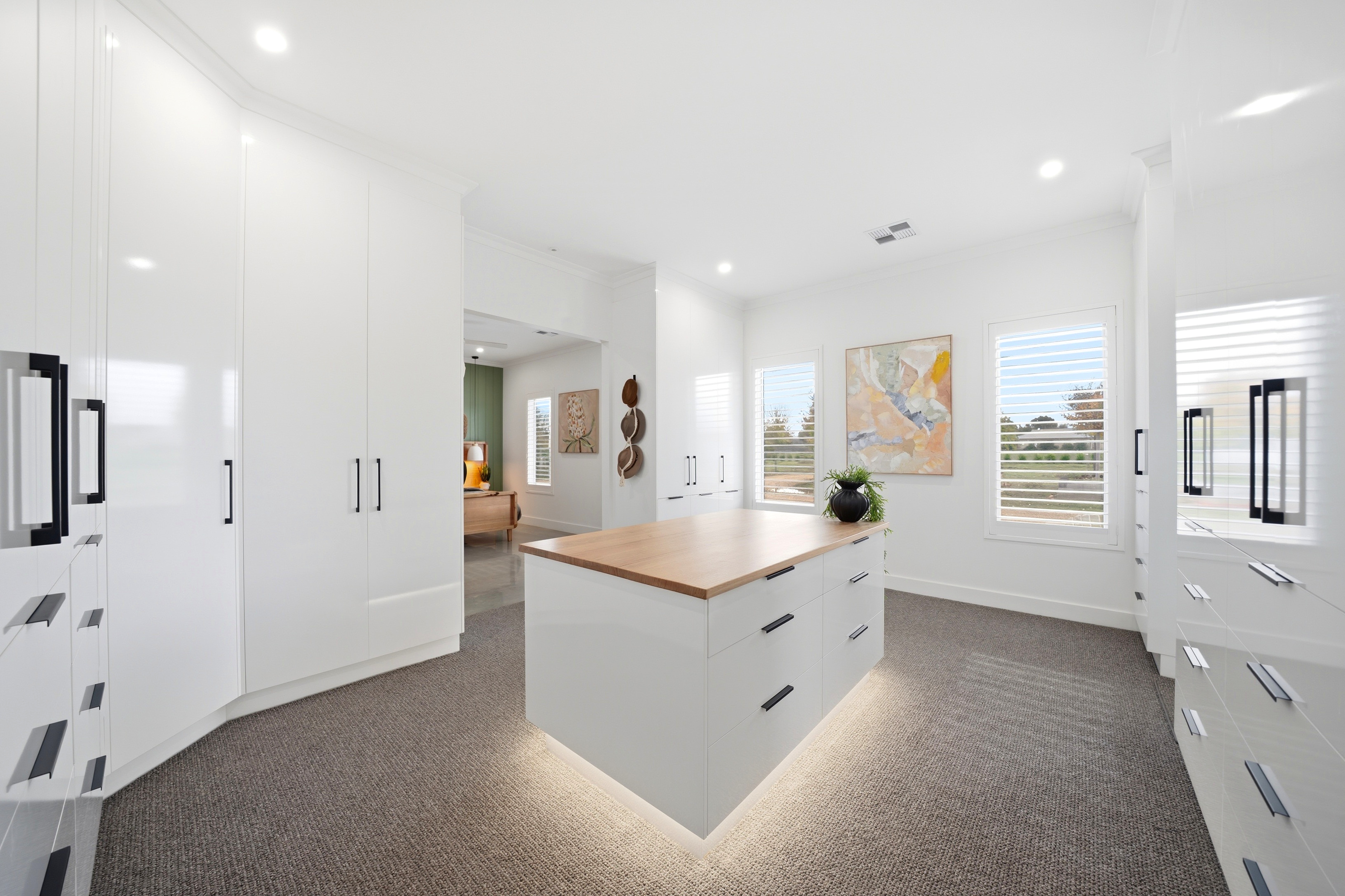 Walk-in robe with island dresser and underlighting