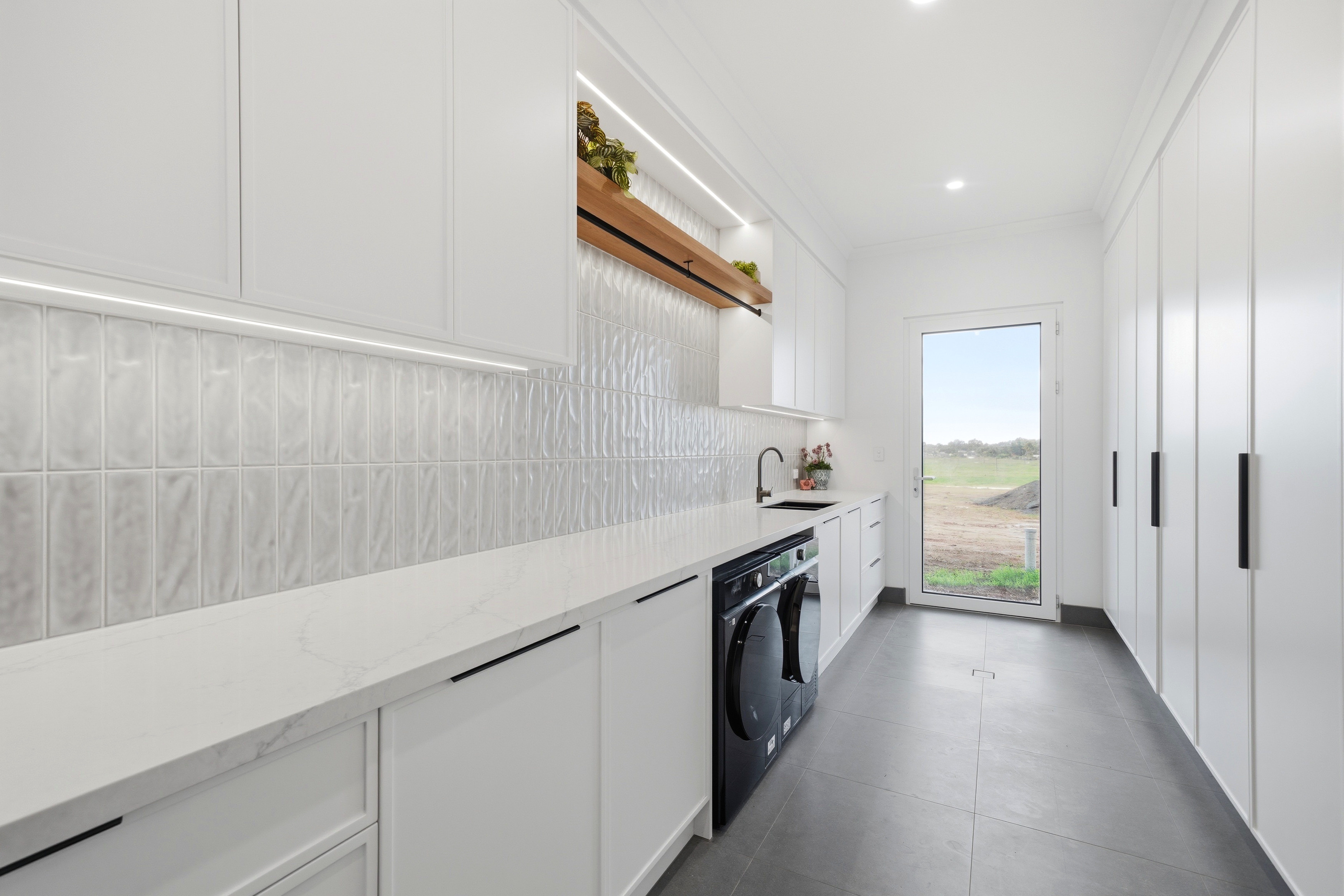 Laundry with textured tile splashback and garden access