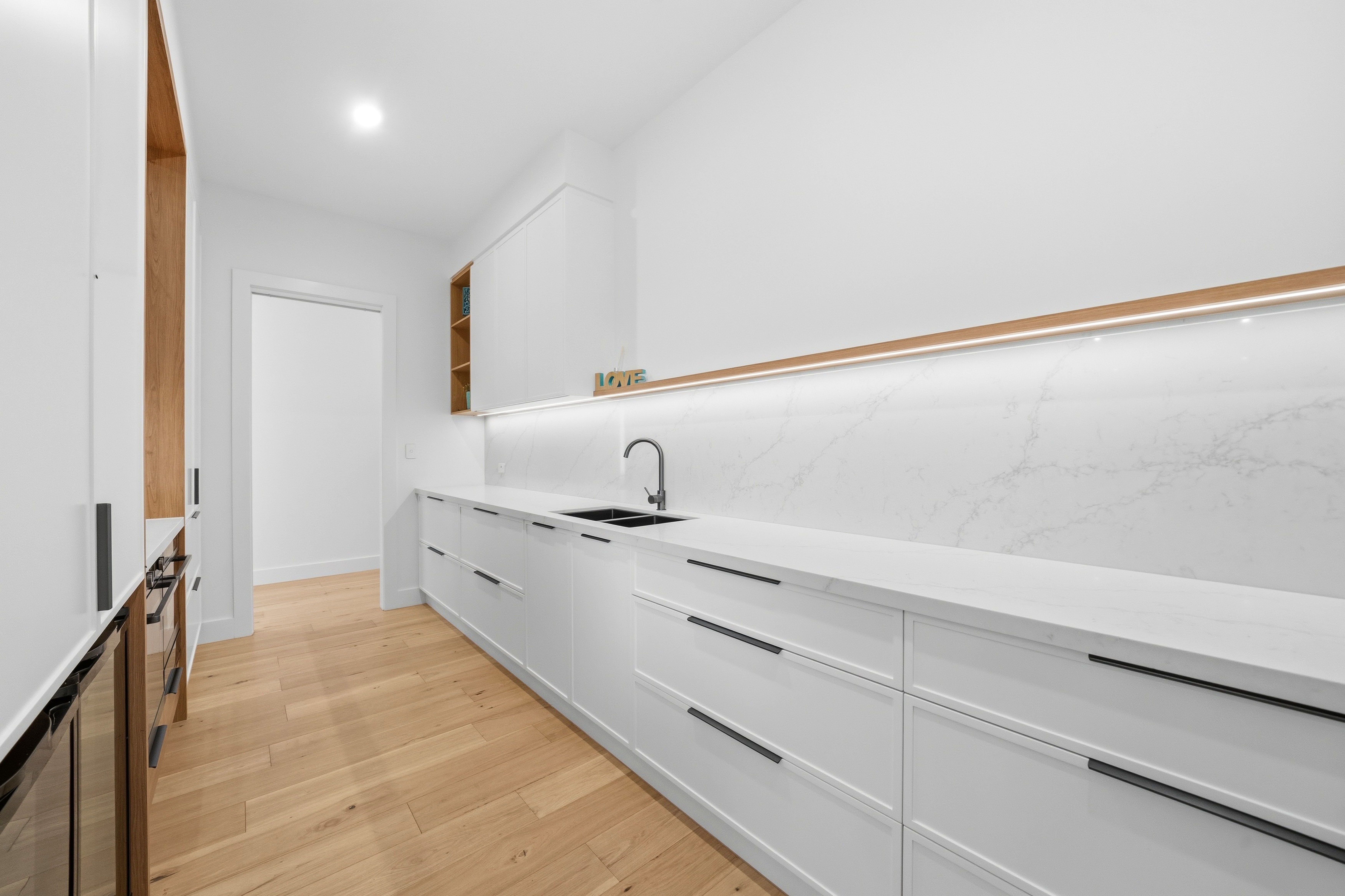 Butler's pantry bench with marble splashback and oak shelving